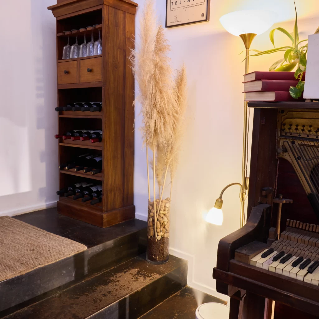 פינת יין מעוצבת במעשנת השוק עם רהיטי עץ ותאורה חמה.