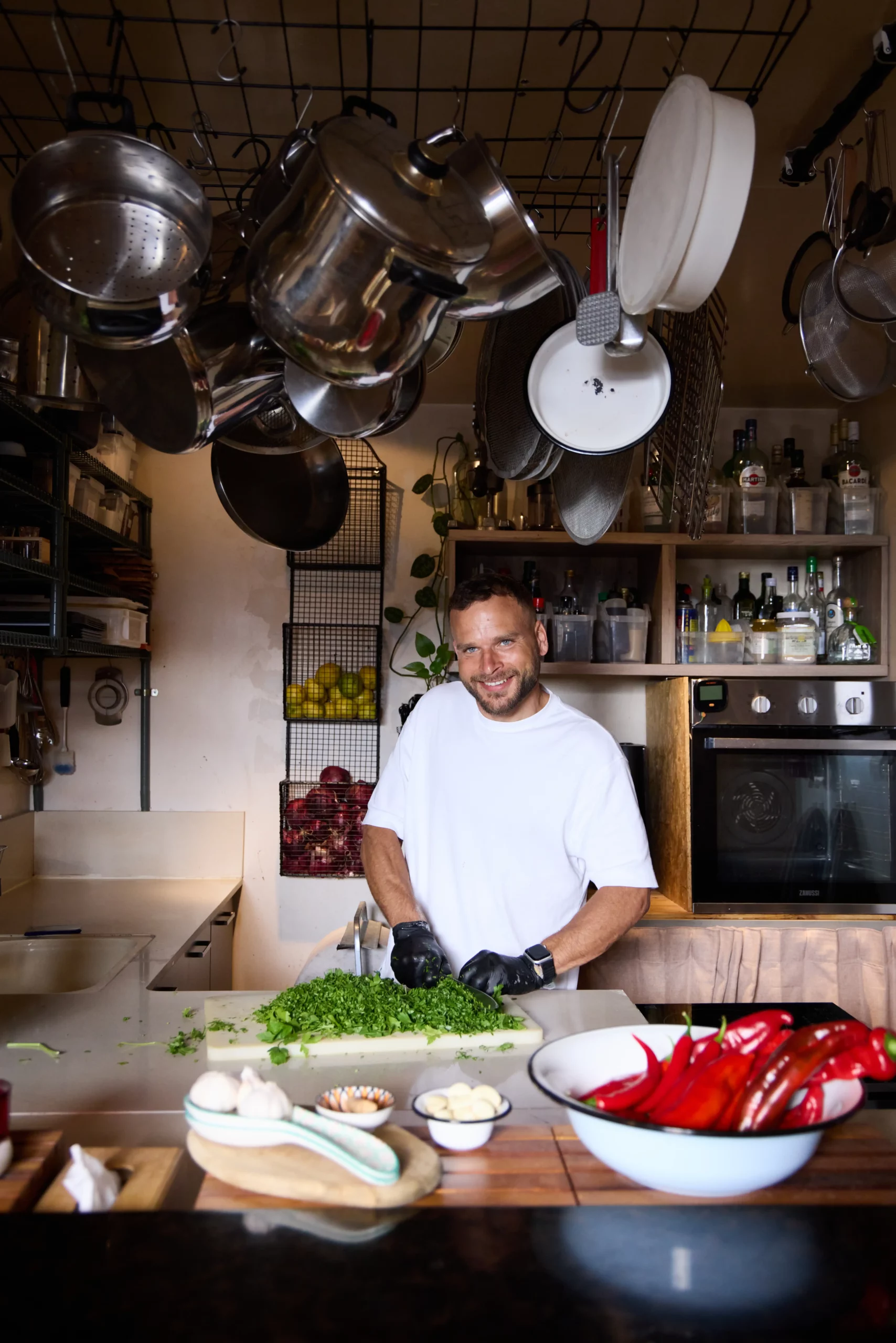 שף פרטי במעשנת השוק חותך עשבי תיבול טריים במטבח המקצועי.